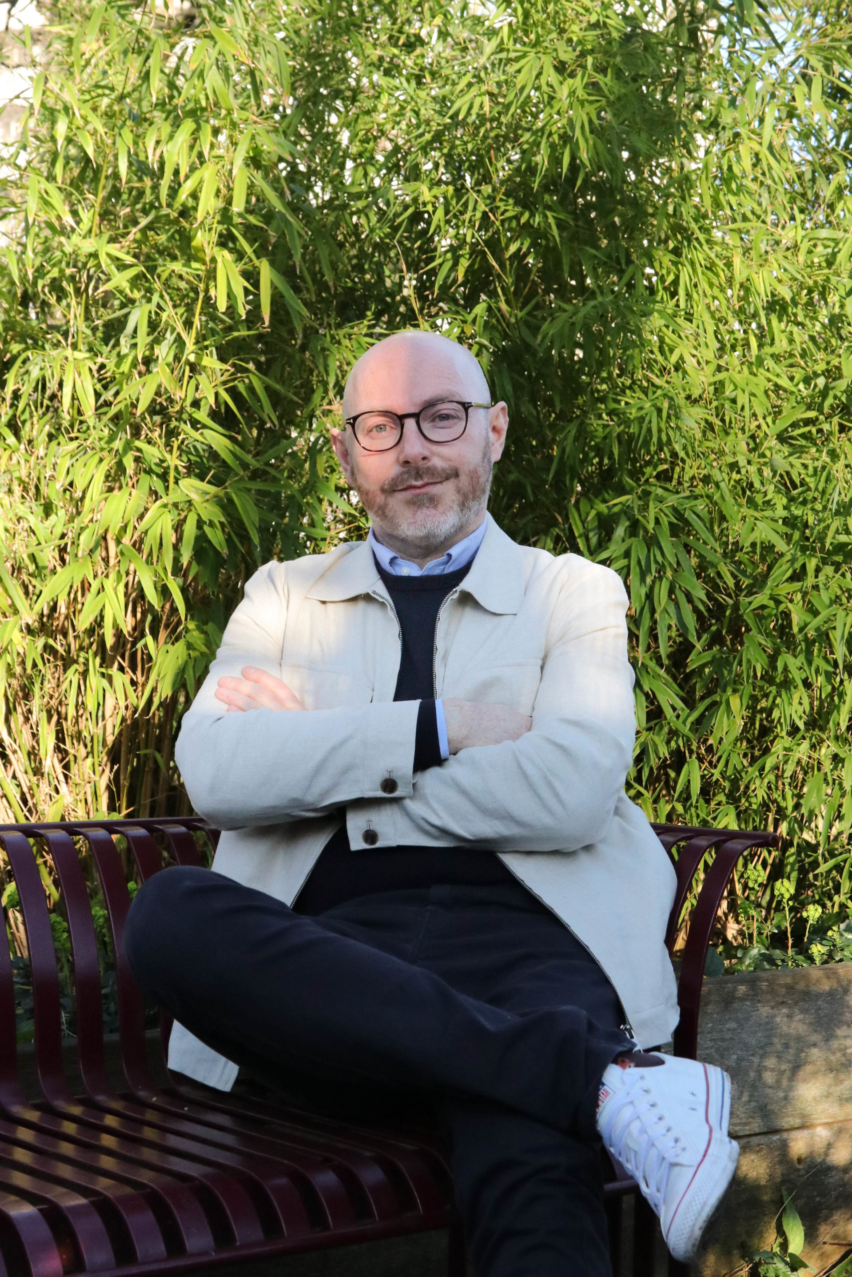 Tom Foulkes, HBs managing director, in a white jacket, discussing 2026 creative trends while seated on a bench.